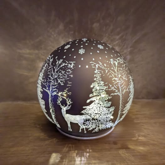 Aldi globe with a winter scene featuring trees and a deer.