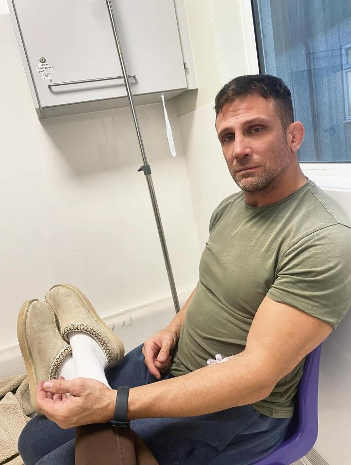 Alex Reid in a hospital, receiving an IV drip in his arm.