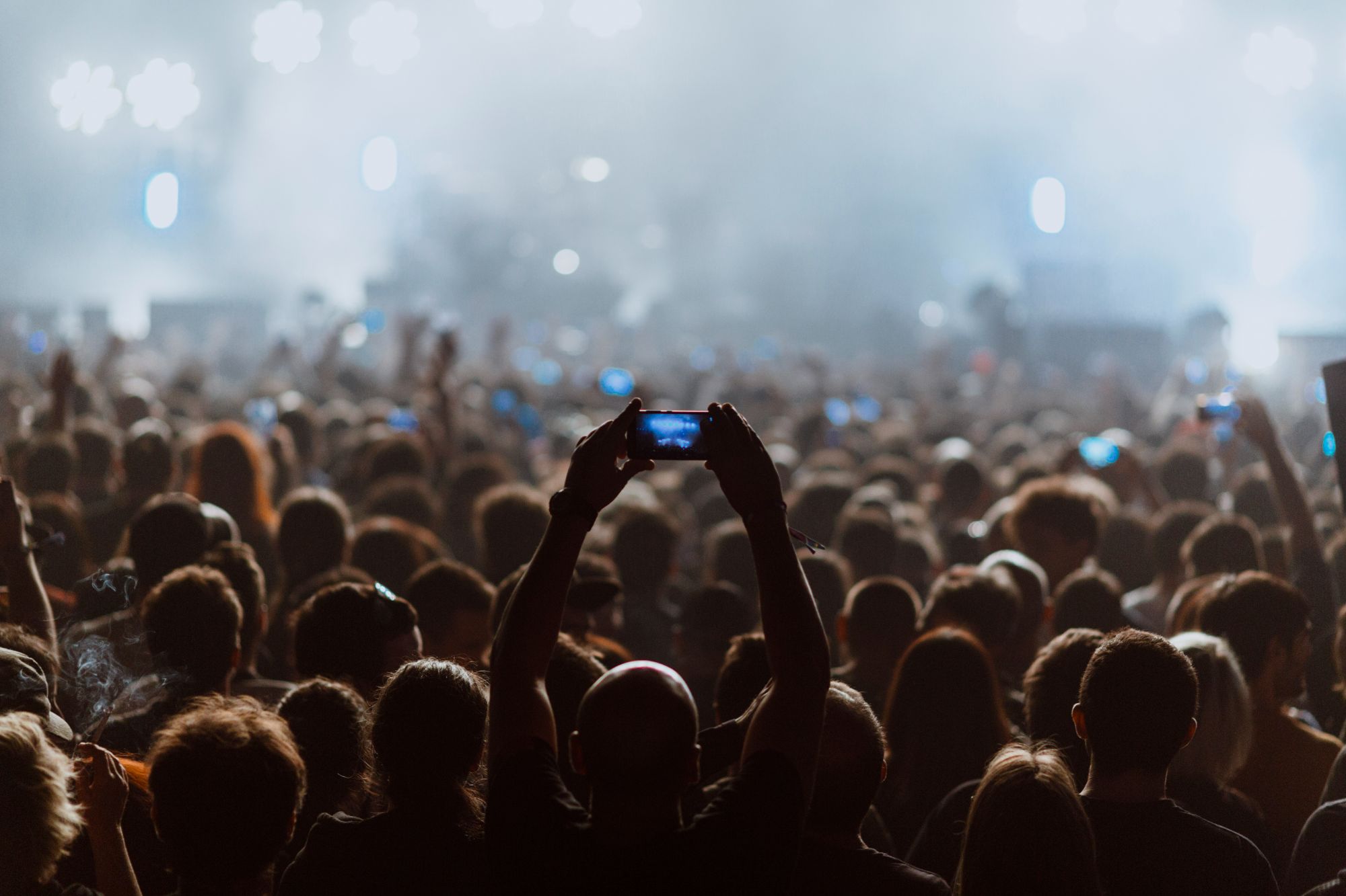 An image collage containing 1 images, Image 1 shows Audience members at a concert recording the performance on their cell phones