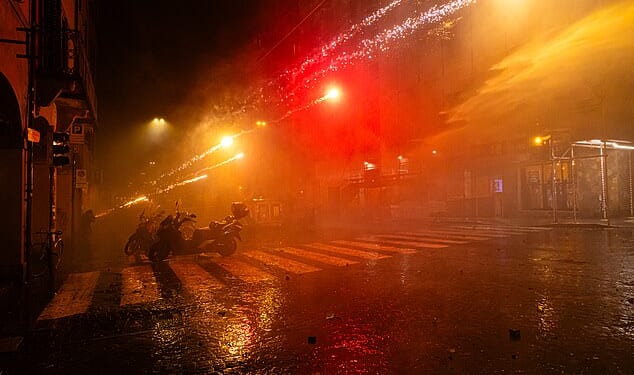 Pro-Palestinian supporters shoot fireworks at police during a protest near the Virtus Arena on November 21, 2025 in Bologna, Italy
