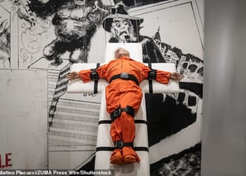 Artwork showing President Donald Trump strapped to a cross-shaped gurney in a prison uniform has popped up in Basel, Switzerland