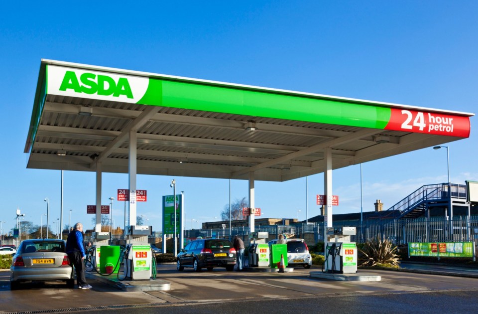 Man putting petrol in his car at an Asda petrol station in the UK.
