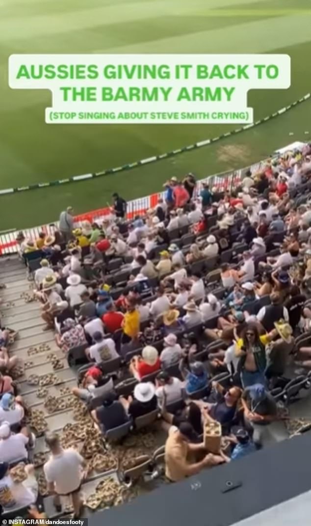 Pictured: A grab from a video showing fans throwing cardboard beer trays down onto English fans during the first Test on Saturday, with the trays littering the aisles