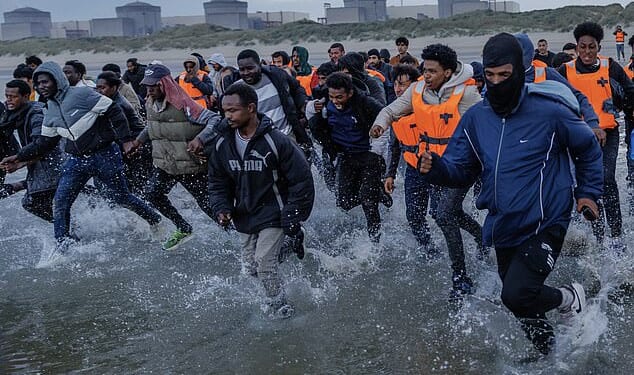 Migrants sprint into the sea at Gravelines beach in northern France in August this year to board a people smugglers' dinghy bound for Britain