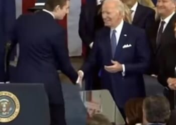 As he shook hands with Biden, he leaned in and whispered something in the departing commander-in-chief's ear