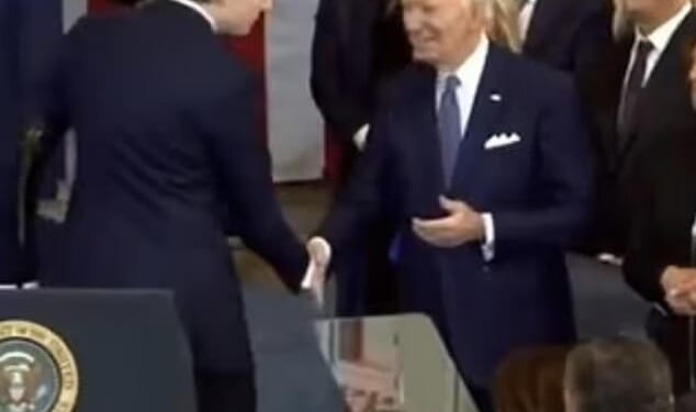 As he shook hands with Biden, he leaned in and whispered something in the departing commander-in-chief's ear