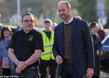 The Prince of Wales walks with Scott Jenkinson, the founder of Youth Shedz during a visit to its headquarters in Conwy