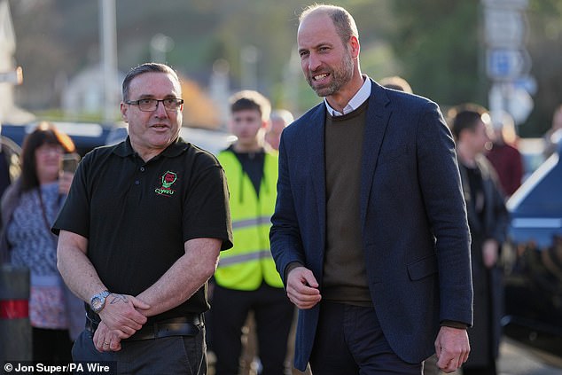 The Prince of Wales walks with Scott Jenkinson, the founder of Youth Shedz during a visit to its headquarters in Conwy