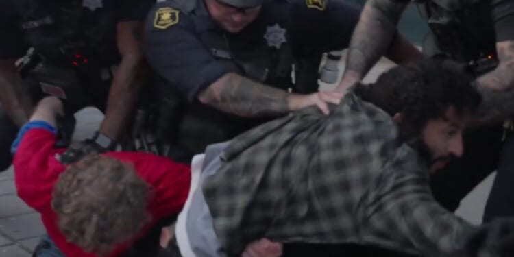 An antifa-linked man, right, and Trump supporter, left, are arrested by police at UC Berkeley at a Turning Point USA event on Monday.