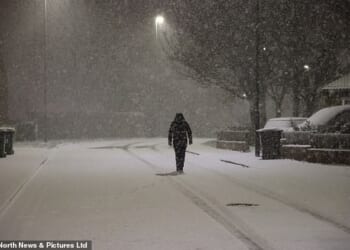 A person walks in the snow in Newcastle early this morning amid whiteout conditions
