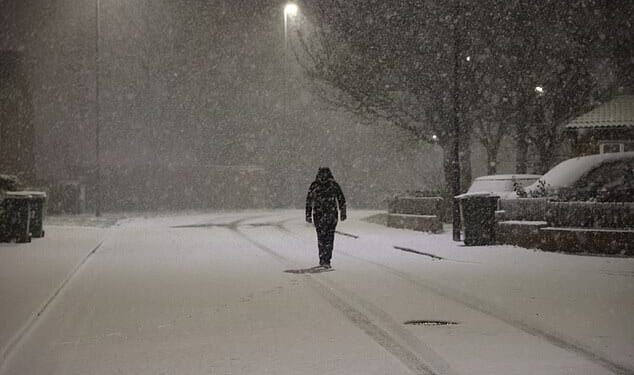 A person walks in the snow in Newcastle early this morning amid whiteout conditions