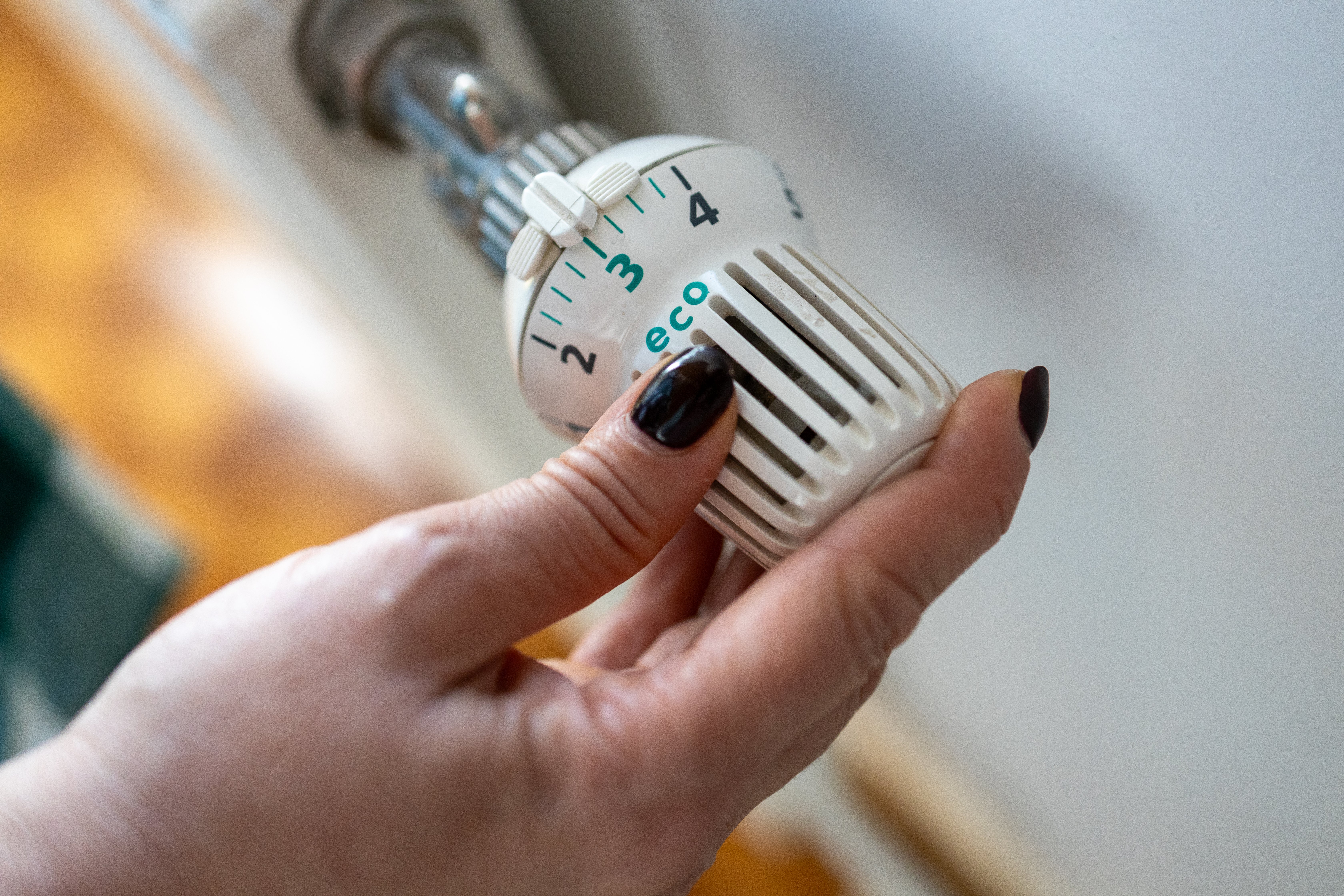A woman's hand turns the battery-powered radiator.