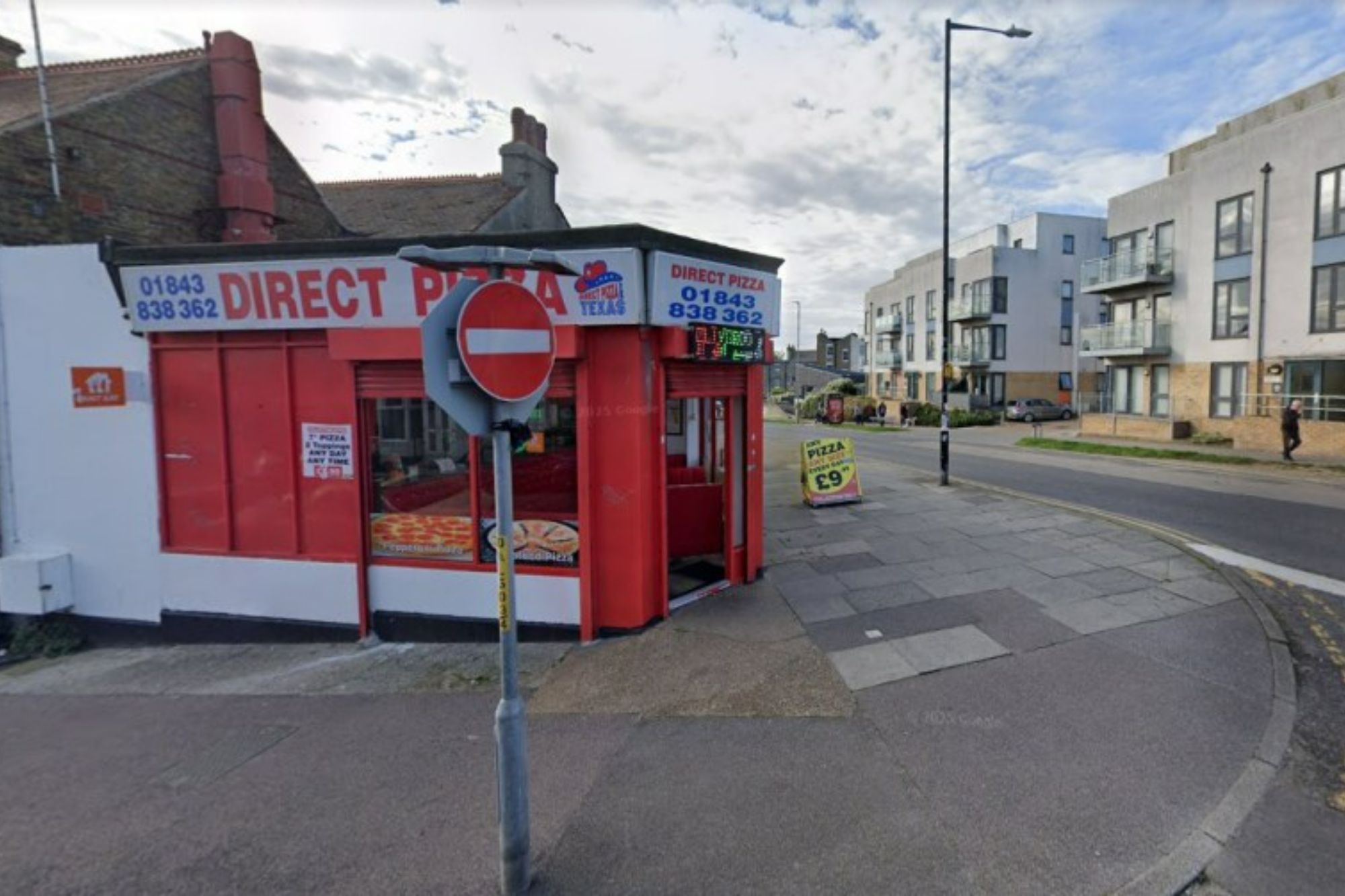 An image collage containing 1 images, Image 1 shows Direct Pizza and Texas takeaway shop on a street corner, with residential buildings across the street