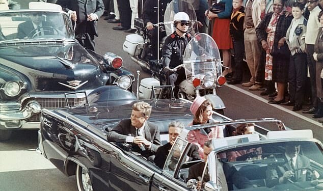 President John F. Kennedy smiles at the crowd that had gathered along the presidential motorcade route in Dallas, Texas, on November 22, 1963