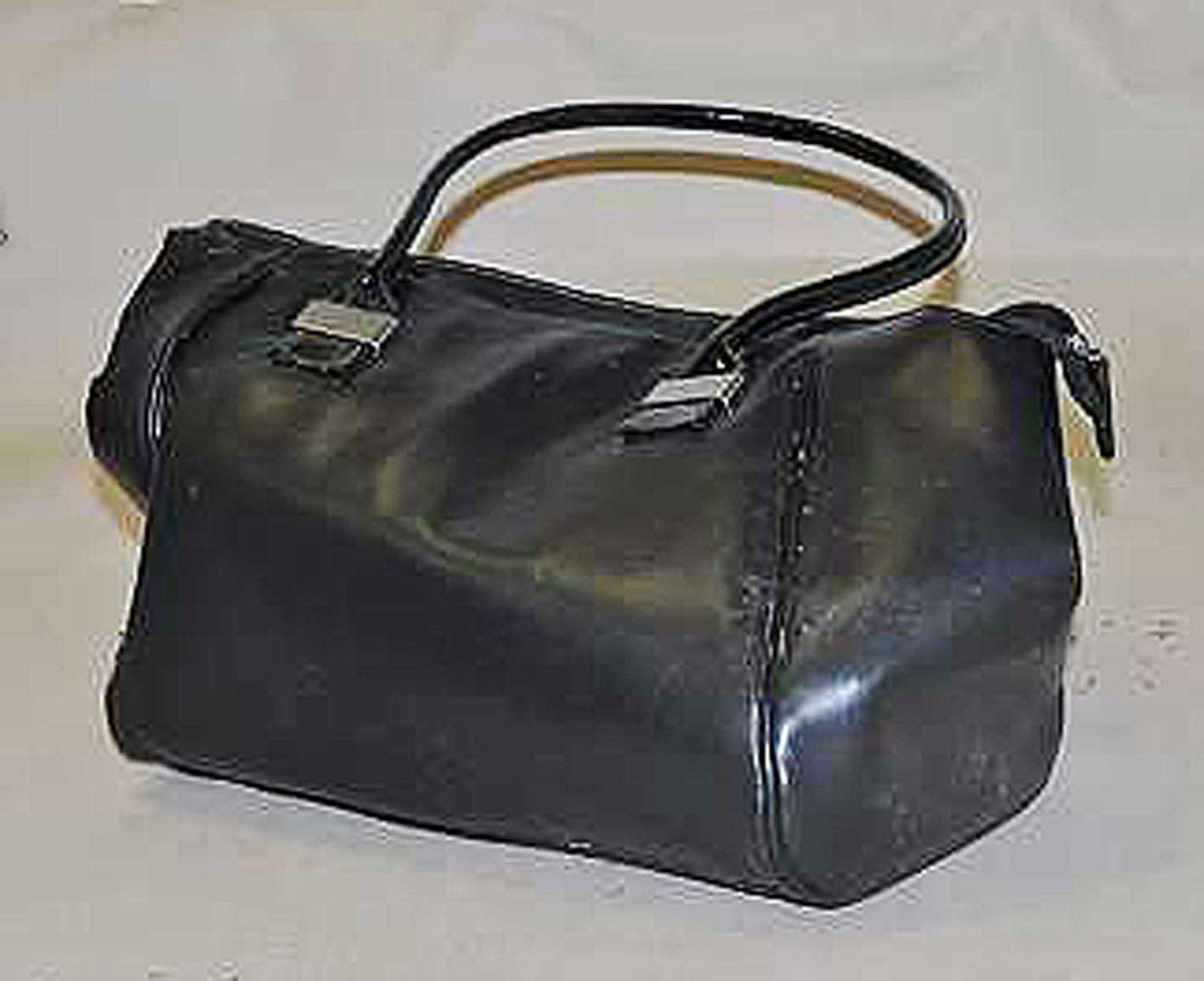 Black handbag with shiny handles.