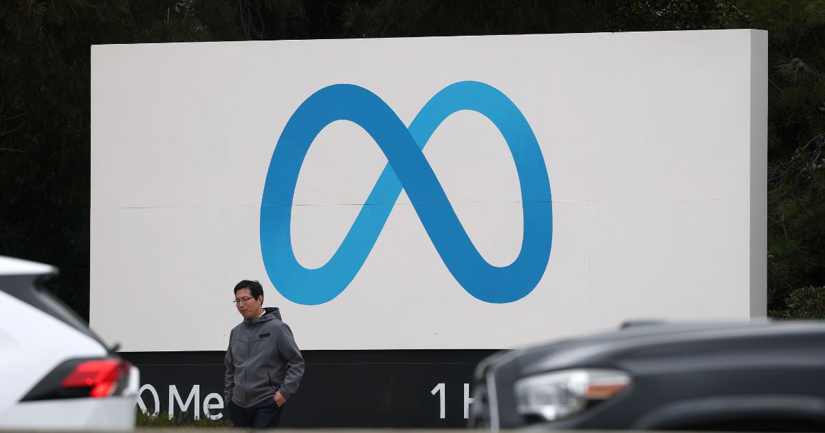 A visitor stands by a sign posted in front of Meta headquarters on Jan. 29, 2025, in Menlo Park, California.