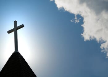 A wooden cross sits on top of a church building.