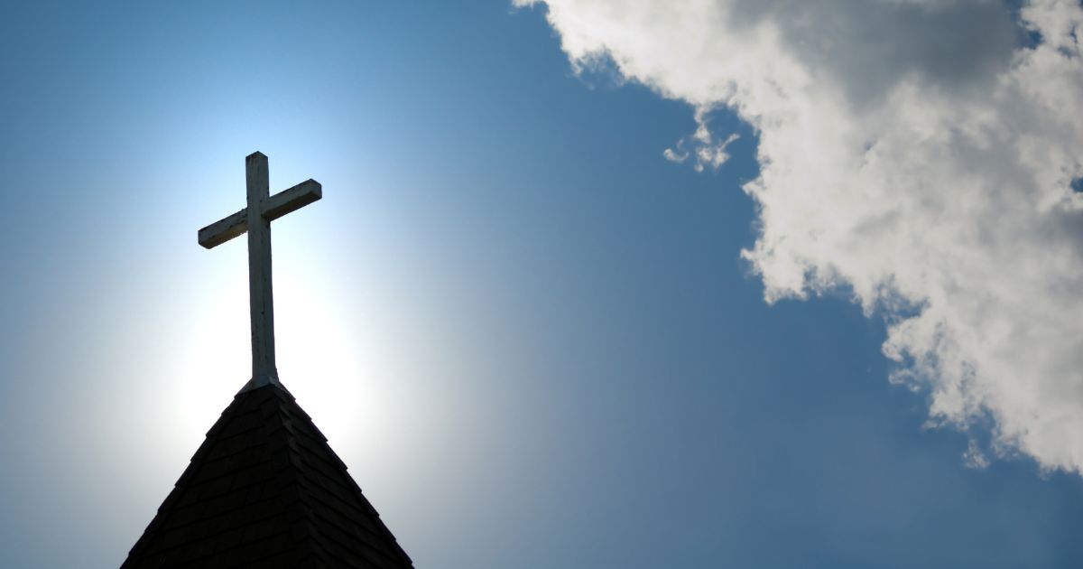 A wooden cross sits on top of a church building.