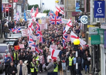 Protesters in Crowborough, East Sussex, hold placards and march through the town centre this morning over plans to house 600 male asylum seekers at Crowborough Training Camp