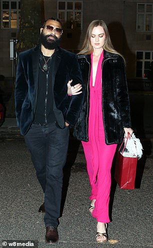 Sian opted for a daring plunging bright pink dress and black leather jacket and she arrived arm in arm with the boxer