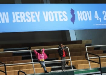 Children stand under a voting banner as they attend a New Jersey Democratic gubernatorial candidate Mikie Sherrill Get Out the Vote Rally at Essex County College Gymnasium on Nov. 1, 2025, in Newark, New Jersey.