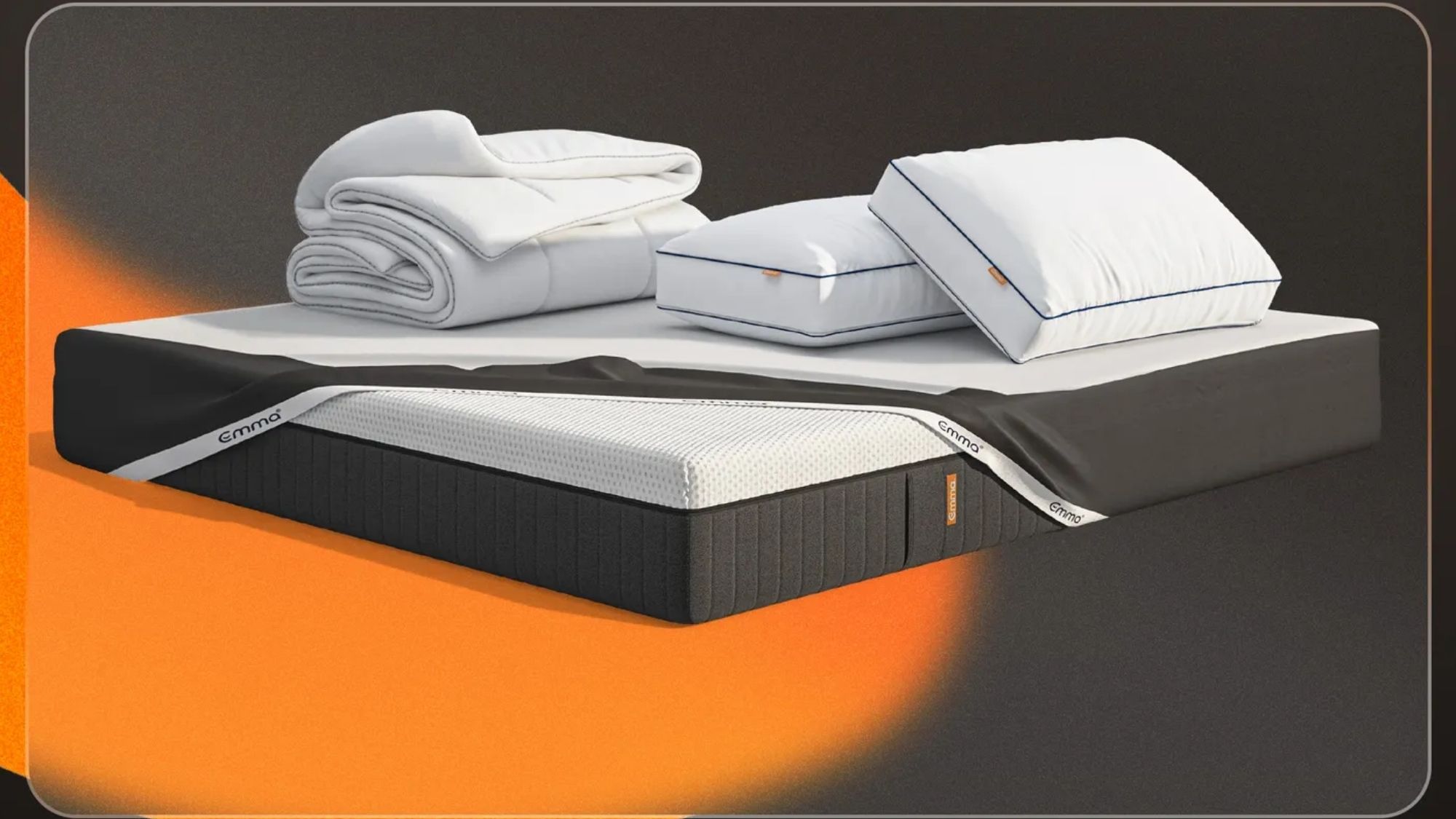 An Emma Hybrid-Luxe mattress with a folded white duvet and two white pillows.