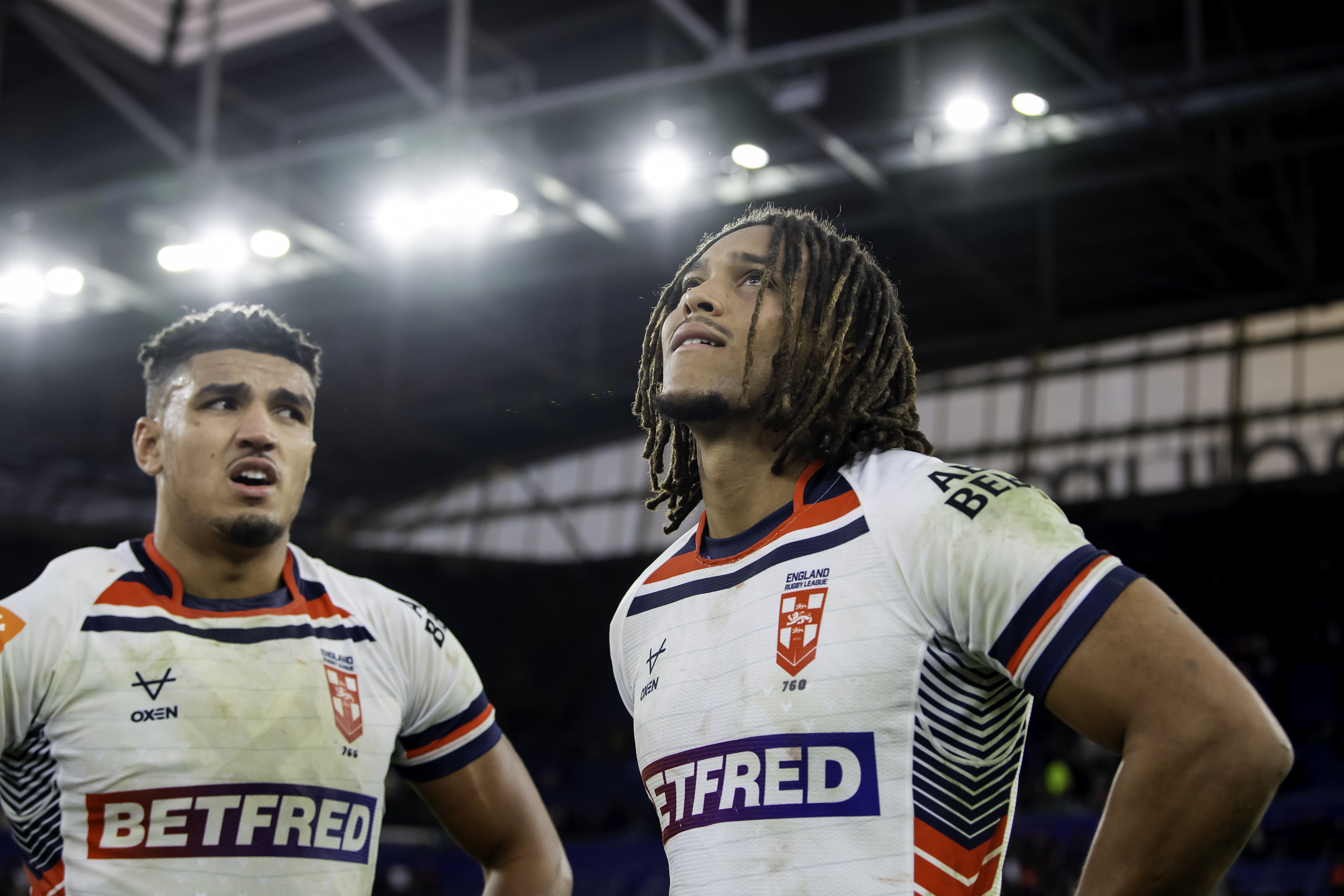 Two rugby players from England look up with expressions of disappointment.