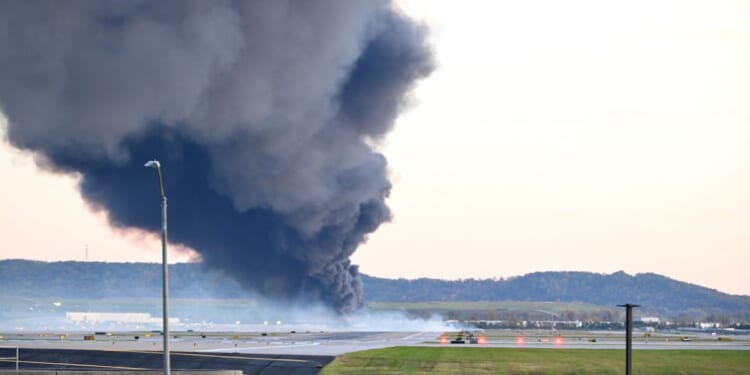 Fire and smoke mark where a UPS cargo plane crashed near Louisville Muhammad Ali International Airport on Nov. 4, 2025, in Louisville, Kentucky.