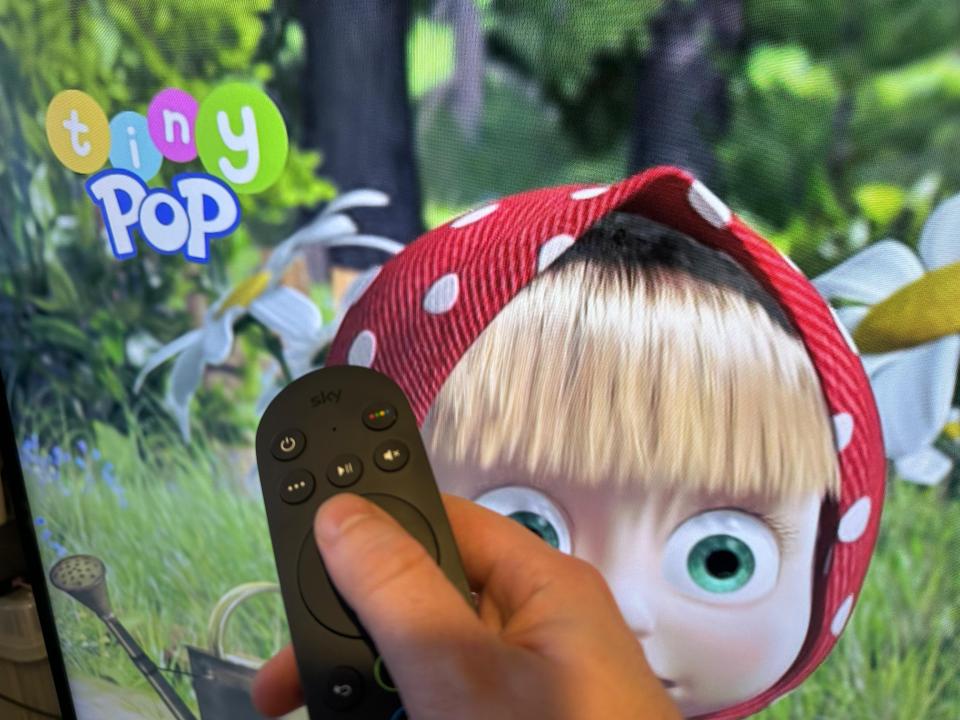a person holding a remote in front of a screen that says tiny pop