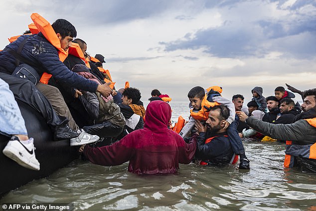 On Saturday the Home Office banned asylum seekers from using taxis, except in the most exceptional circumstances. Pictured: Migrants board a dinghy in the English Channel