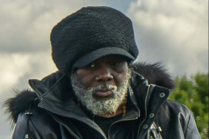 Franklin Francis wearing a black hat and jacket with a fur collar.