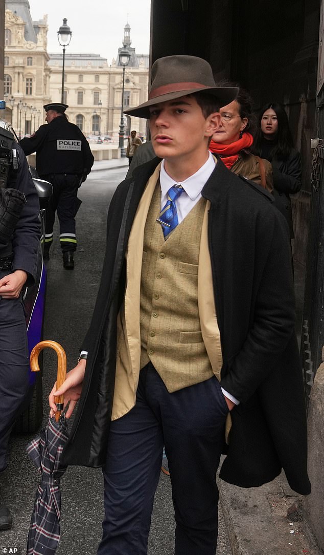 With a brown fedora tipped over one eye and a Yves Saint Laurent waistcoat, Pedro Elias Garzon Delvaux strutted past three police officers leaning against a silver car