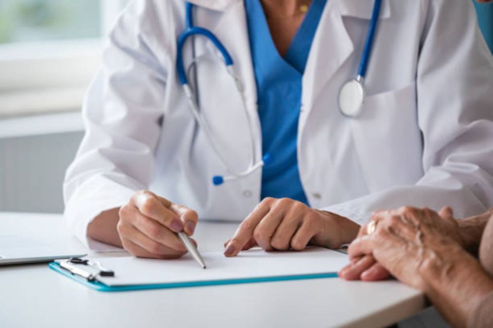 An image collage containing 1 images, Image 1 shows A doctor in a white coat and stethoscope pointing to a document on a clipboard for a patient