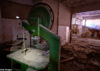 A band saw stands beside two bone cutting saws in a room flooded with excrement inside Sednaya Prison, where thousands of people were detained and tortured