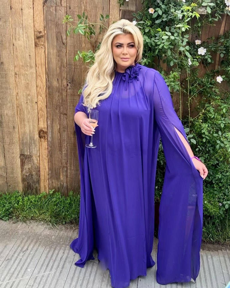 Gemma Collins in a flowing purple gown holding a glass of champagne at the Chelsea Flower Show.