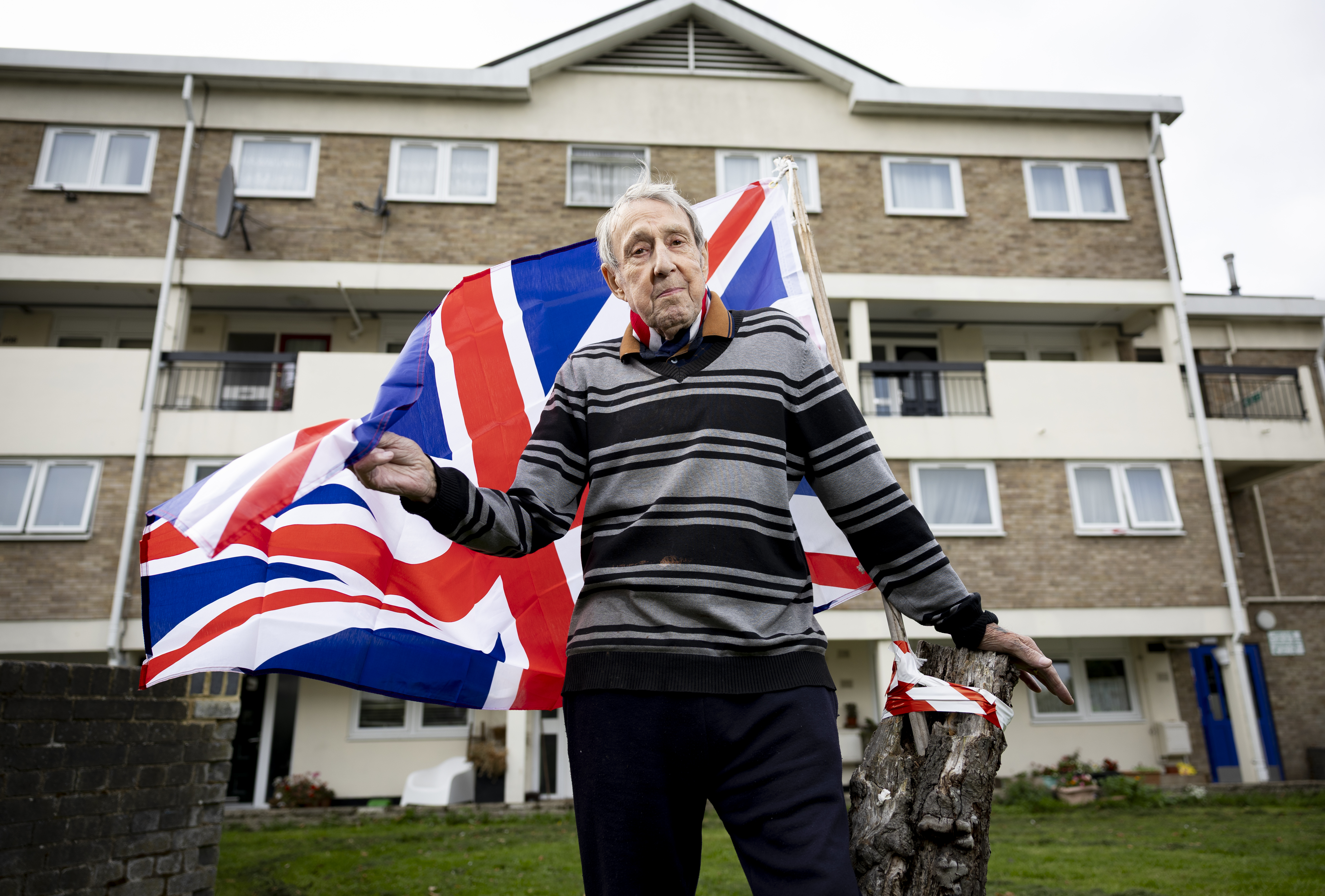 Ray Betts, 86, flying a Union Flag from a tree stump outside his East London home.