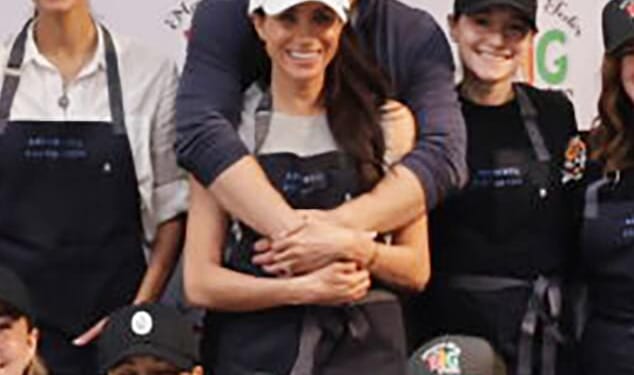 Harry wraps his arms around his wife in a show of unity in a new image of the couple released last night