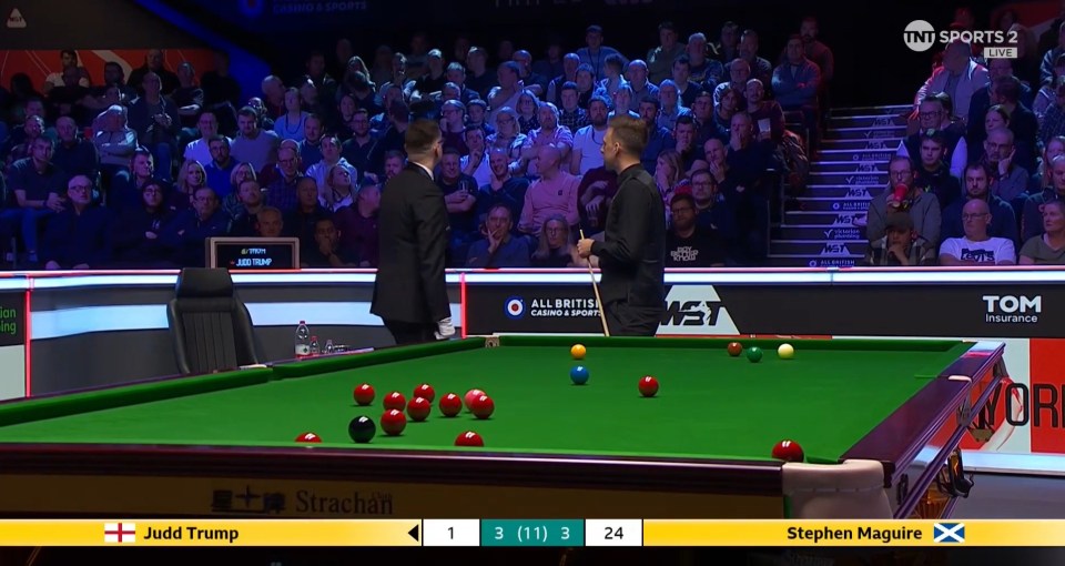 Two men play snooker in front of a live audience.