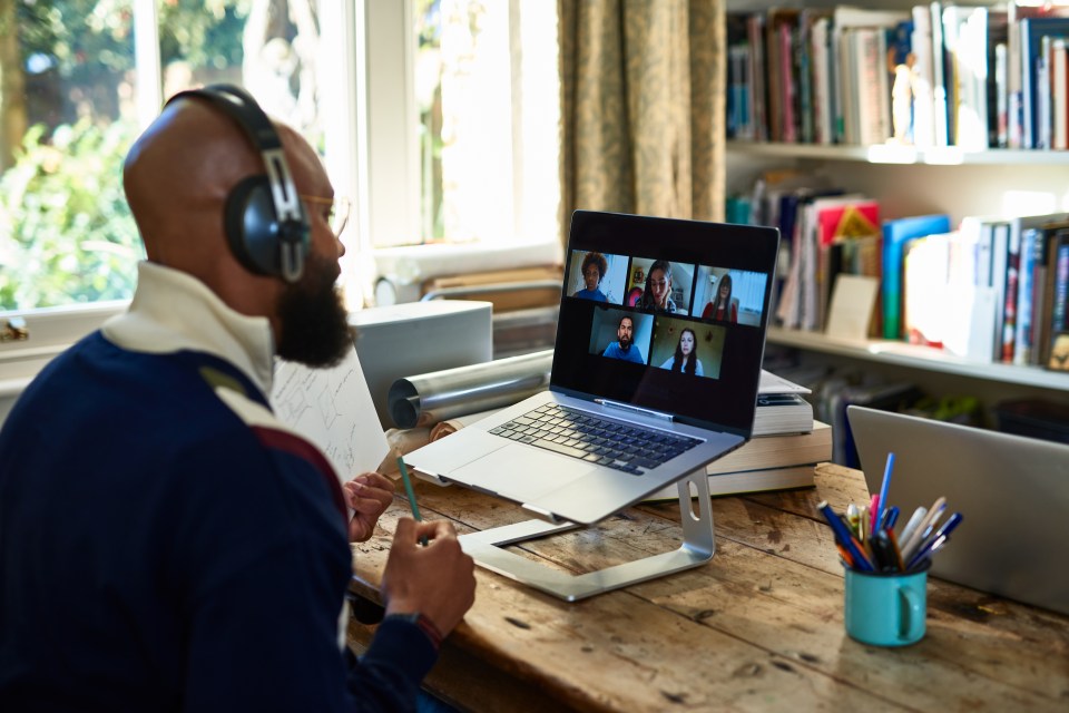 A Black man on a video conference call with colleagues from his home office.