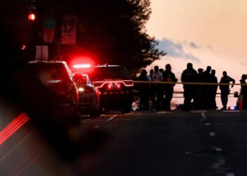 Law enforcement officials gather near the site where to National Guardsmen were shot, one fatally, in Washington, DC on Nov. 26, 2025.
