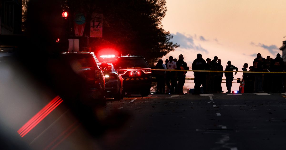 Law enforcement officials gather near the site where to National Guardsmen were shot, one fatally, in Washington, DC on Nov. 26, 2025.