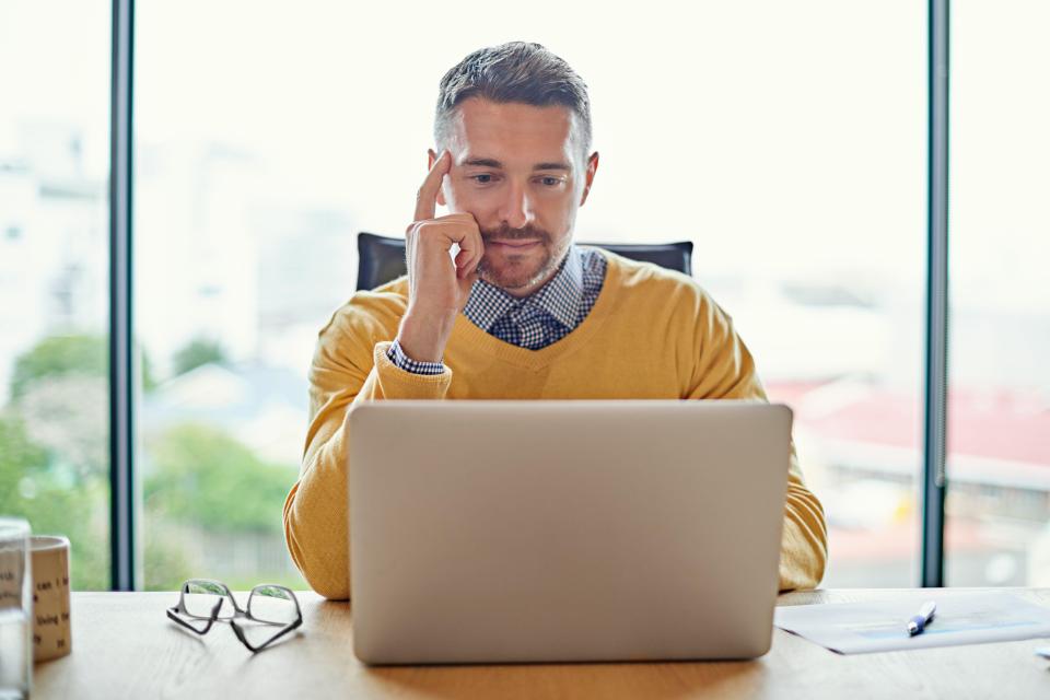 A businessman working on his laptop at his desk.