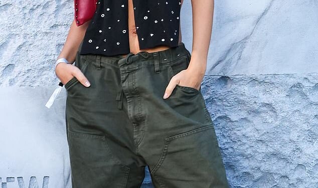 Model Emily Ratajkowski is pictured wearing oversized khaki cargo trousers in Paris in 2024 for a Vans event