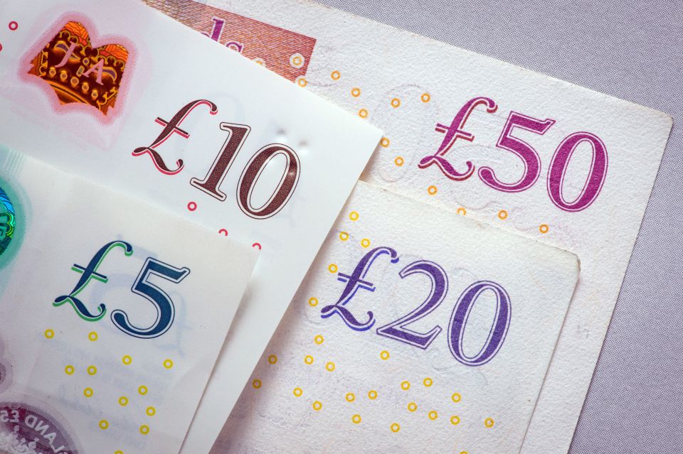 Close-up of £5, £10, £20, and £50 British banknotes, illustrating different values of currency.