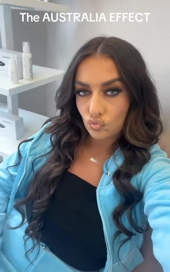 A woman in a light blue tracksuit making a kissing face at the camera, with text overlay "The AUSTRALIA EFFECT".