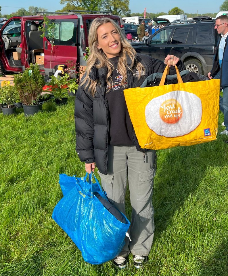 A woman at a market holding a yellow Aldi shopping bag with a fried egg and the text "You crack me up!" and a blue bag.