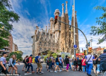 A large group of tourists walks in front of Antoni Gaudi's Sagrada Familia church in Barcelona