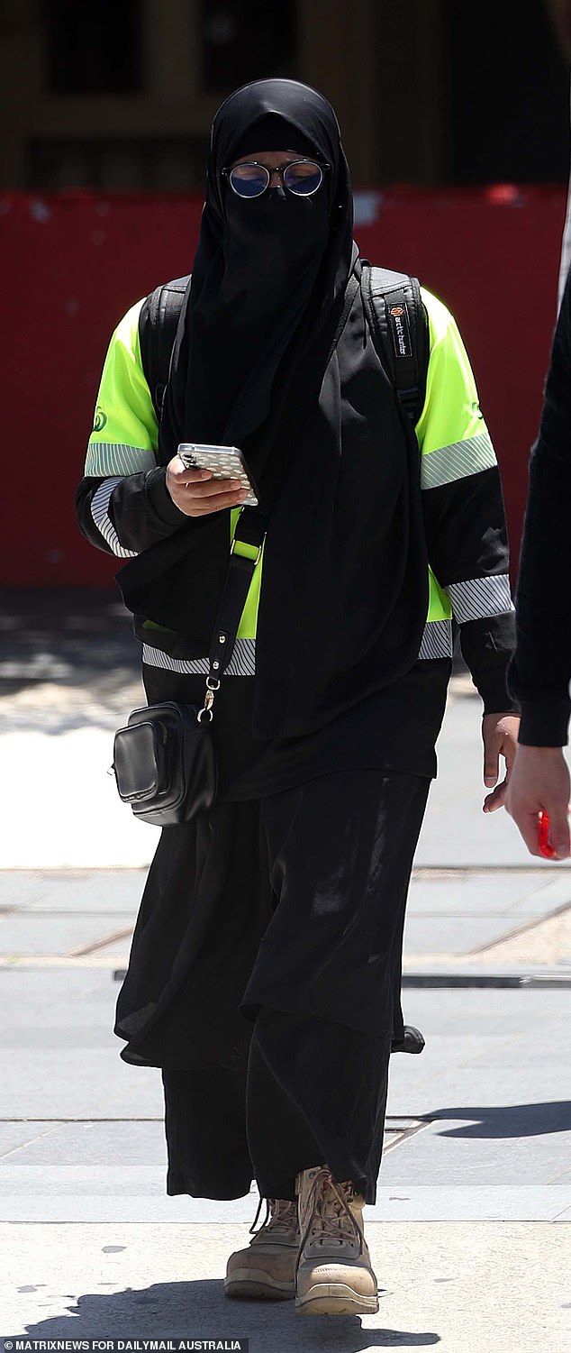 A woman is seen wearing a hi-vis, work boots and a niqab on Tuesday in western Sydney