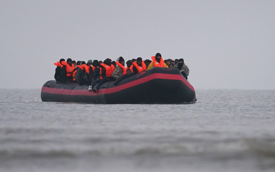 Migrants in a small boat on the water.