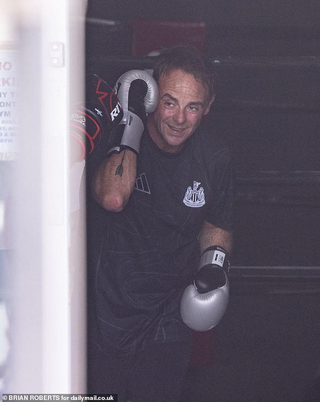 Dressed in a full black outfit of t-shirt and shorts, the father-of-one draped a blue and white stripy towel when he emerged from the gym looking worn out